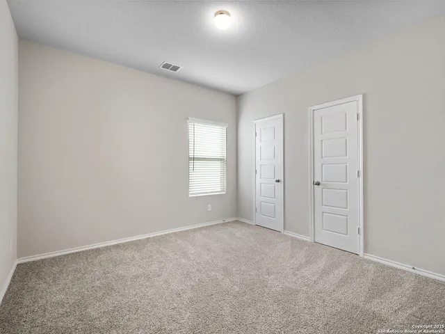 an empty room with windows and closet