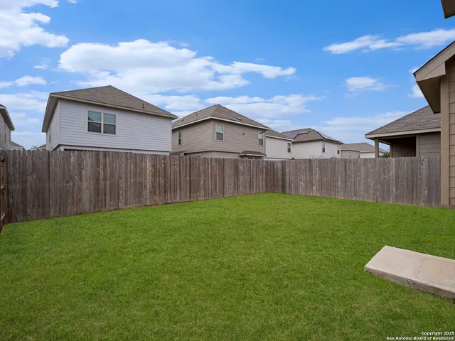 a view of a backyard with wooden fence