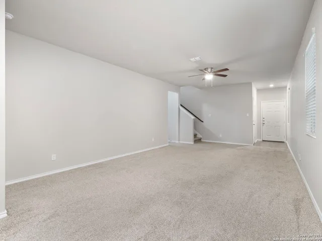 a view of a livingroom with a ceiling fan and window