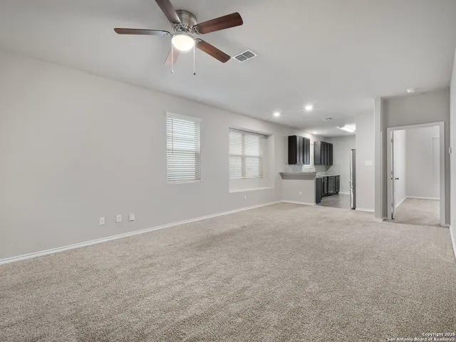 a view of large windows and a kitchen with a ceiling fan