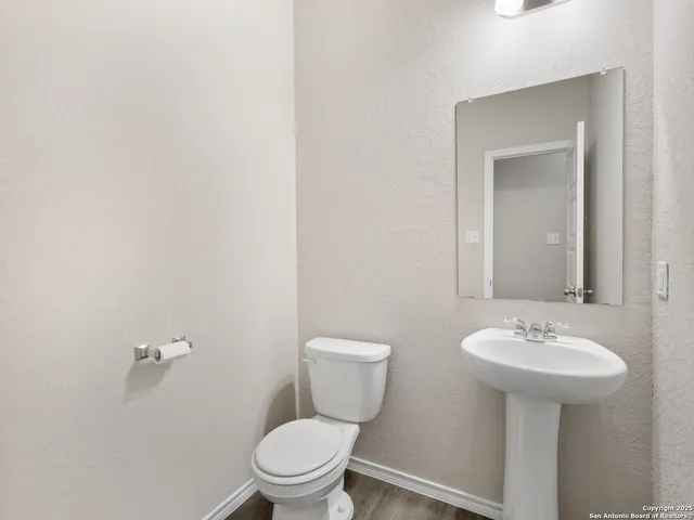 a bathroom with a toilet sink and mirror