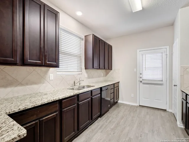 a kitchen with granite countertop stainless steel appliances a sink stove and cabinets
