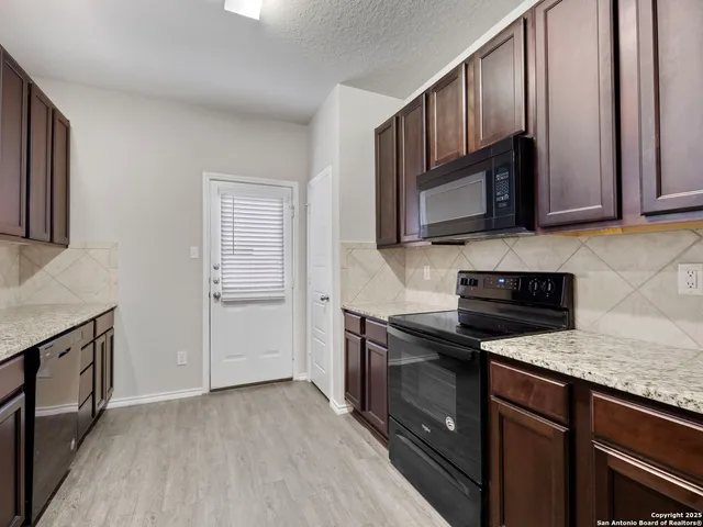 a kitchen with granite countertop wooden cabinets and stainless steel appliances