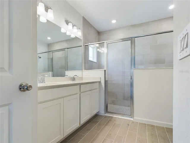 a bathroom with a shower sink vanity and mirror