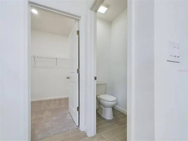 a view of bathroom with a toilet sink and mirror