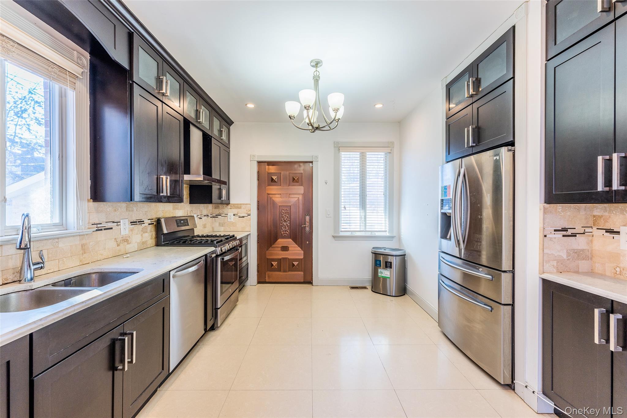 53-12 199th Street Queens, NY 11365 - Photo 11 of 31 a kitchen with stainless steel appliances granite countertop a refrigerator a stove a sink and a microwave
