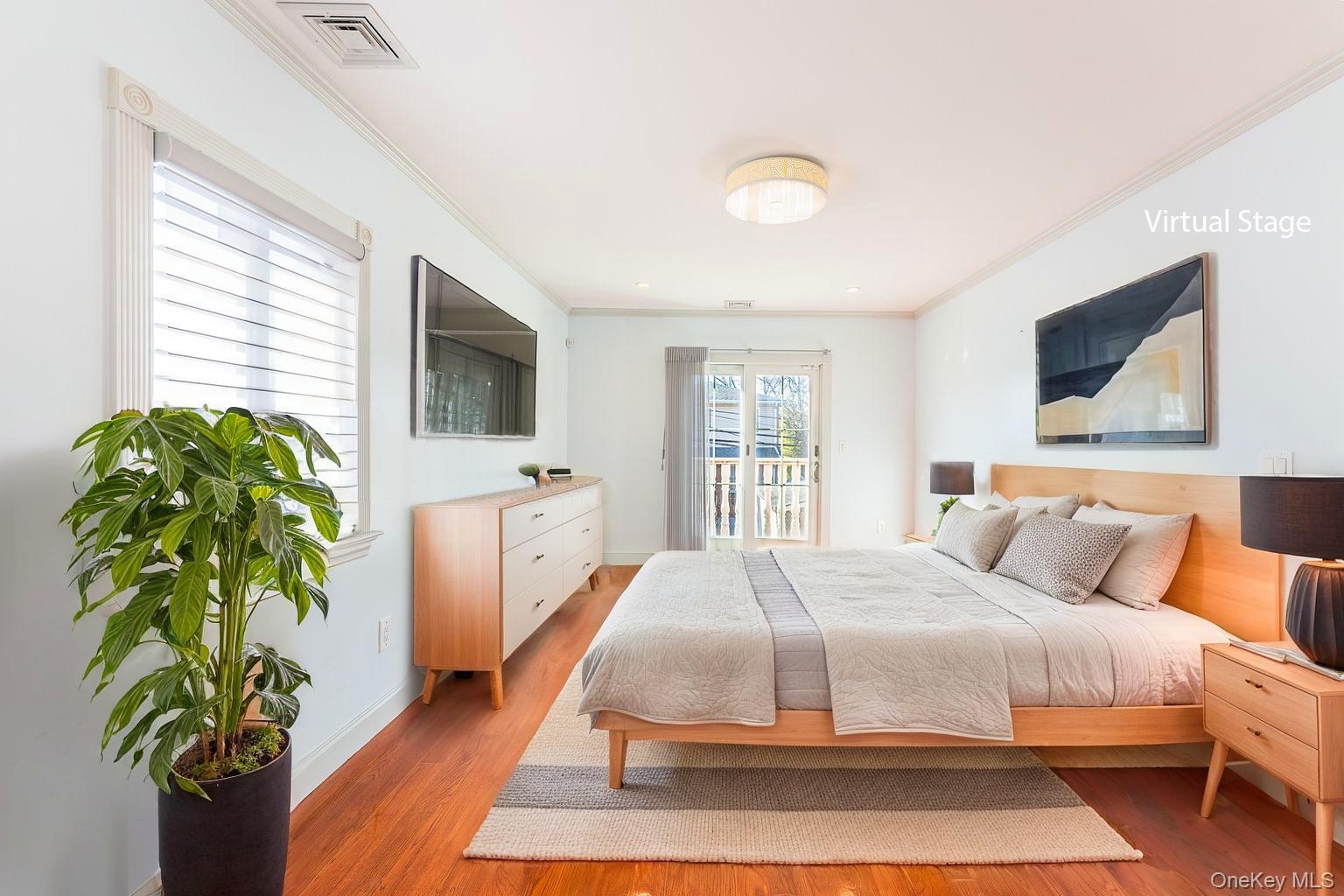 53-12 199th Street Queens, NY 11365 - Photo 15 of 31 a bedroom with a balcony a bed and a flat screen tv