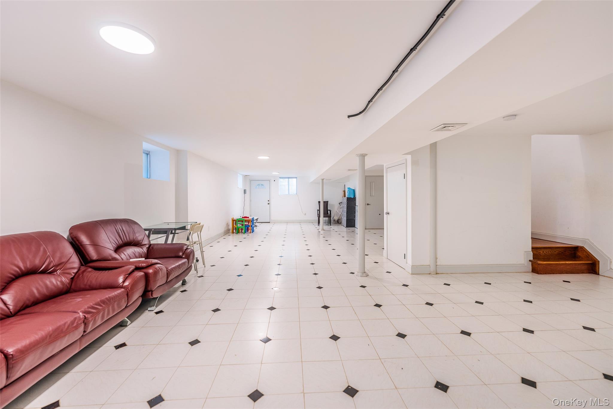 53-12 199th Street Queens, NY 11365 - Photo 22 of 31 a living room with furniture and a refrigerator