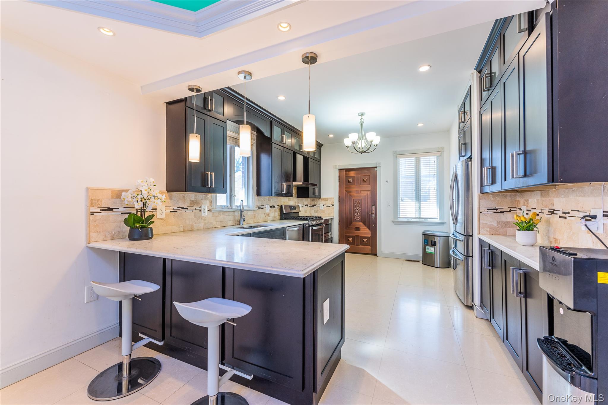 53-12 199th Street Queens, NY 11365 - Photo 10 of 31 a kitchen with stainless steel appliances kitchen island granite countertop a table chairs in it and wooden floors