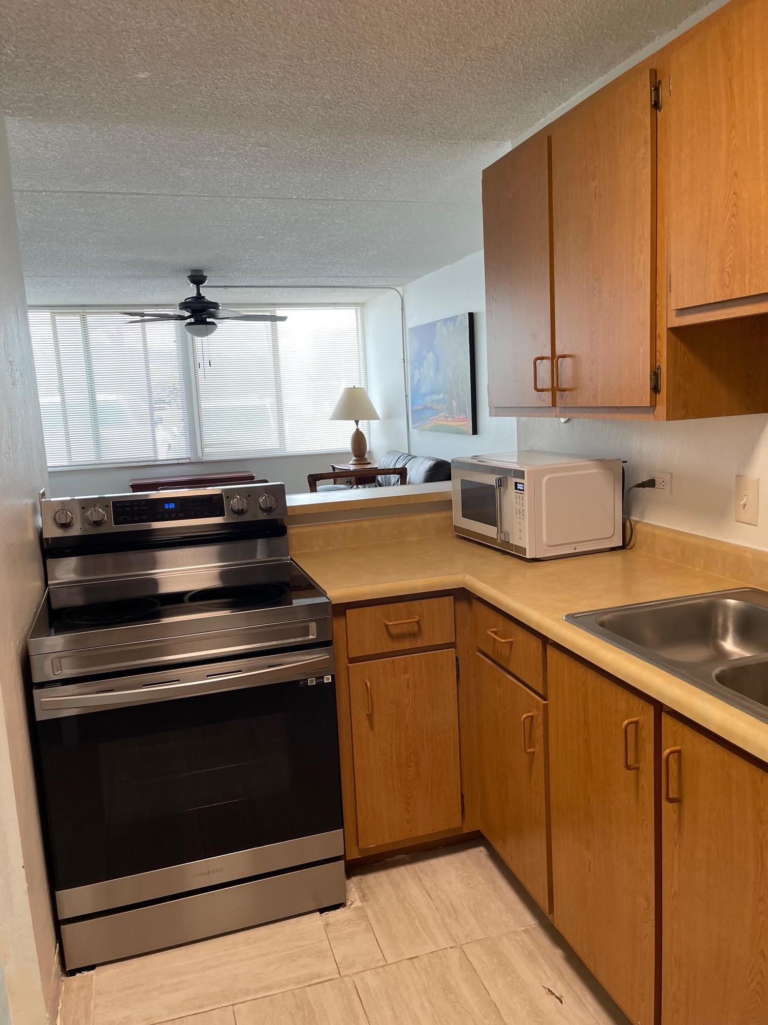 111 Kahului Beach Road, Unit D112 Kahului, HI 96732 - Photo 18 of 29 a kitchen with a stove cabinets and a sink