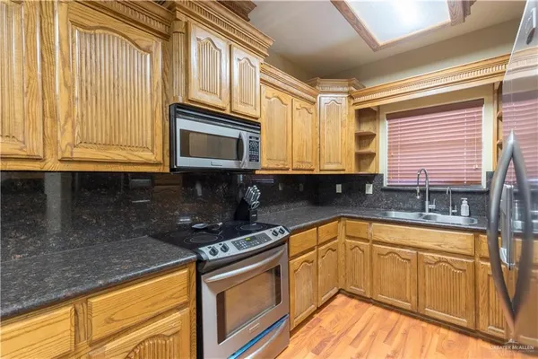 a kitchen with stainless steel appliances granite countertop white cabinets granite counter tops and a window