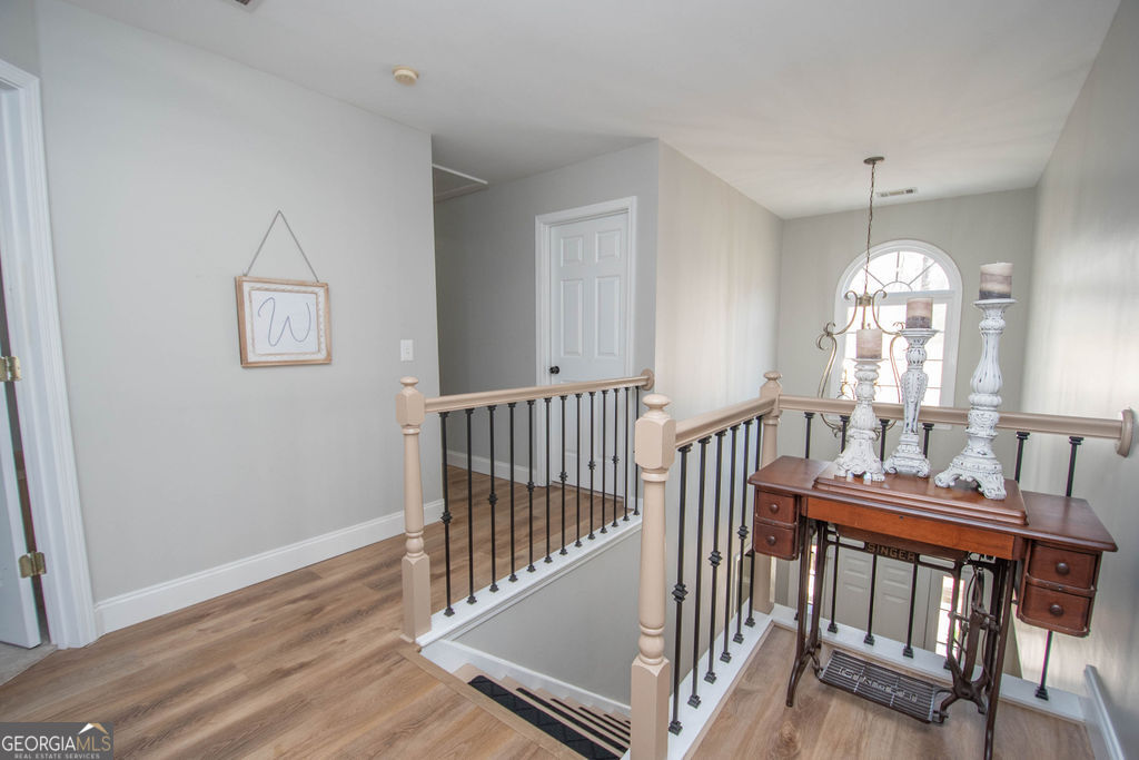 100 Spring Forest Trail Sharpsburg, GA 30277 - Photo 15 of 39 an empty room with wooden floor windows and a chandelier