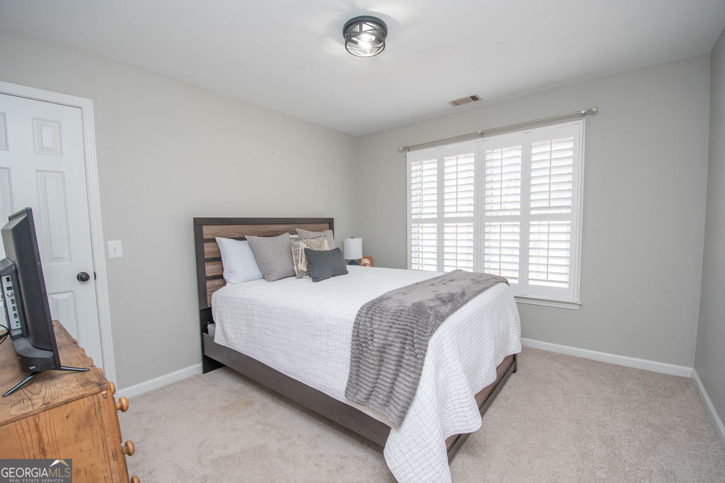 100 Spring Forest Trail Sharpsburg, GA 30277 - Photo 22 of 39 a bed sitting in a bedroom next to a window