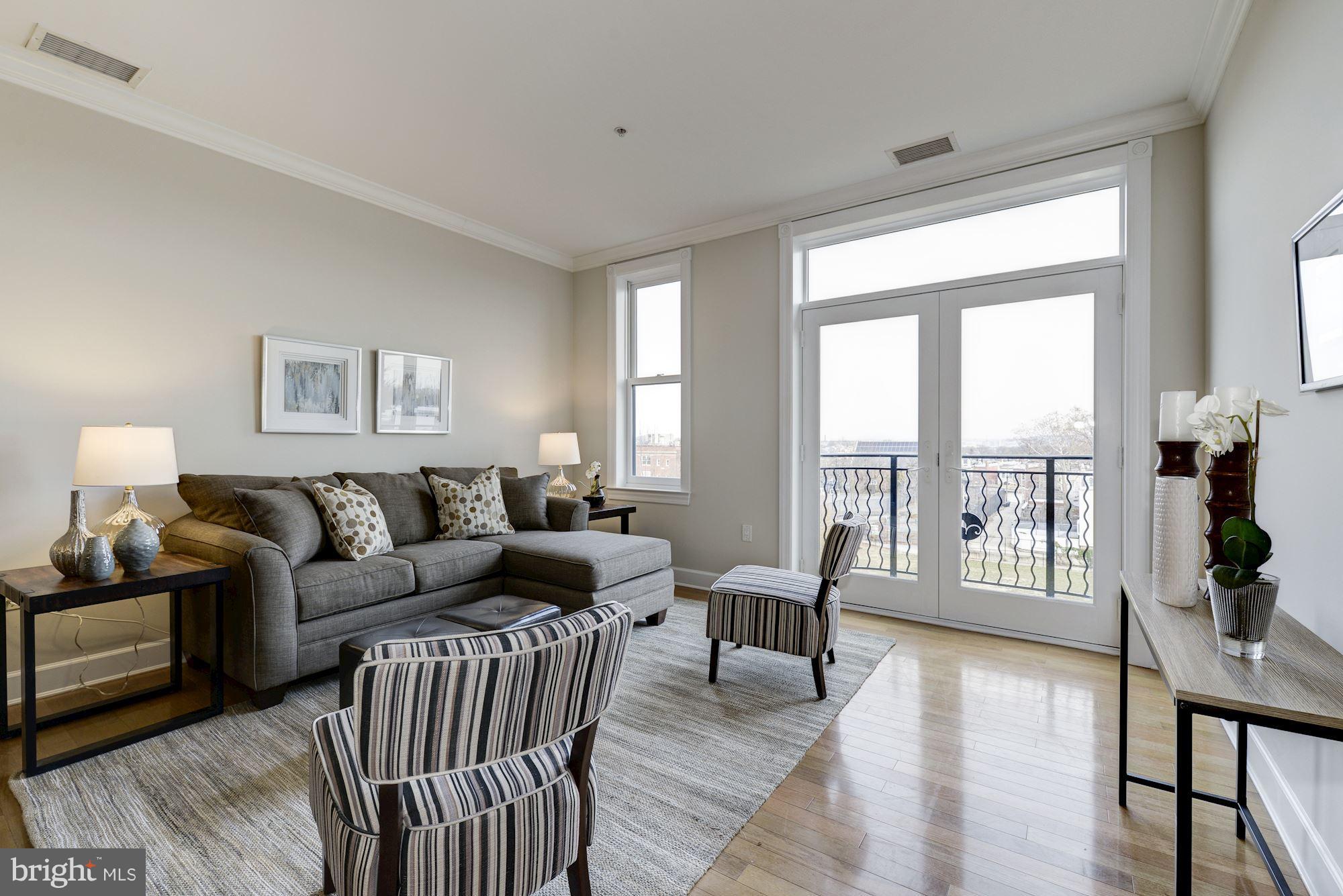401 13th Street Northeast, Unit PH8 Washington, DC 20002 - Photo 13 of 27 a living room with furniture and a large window with wooden floor