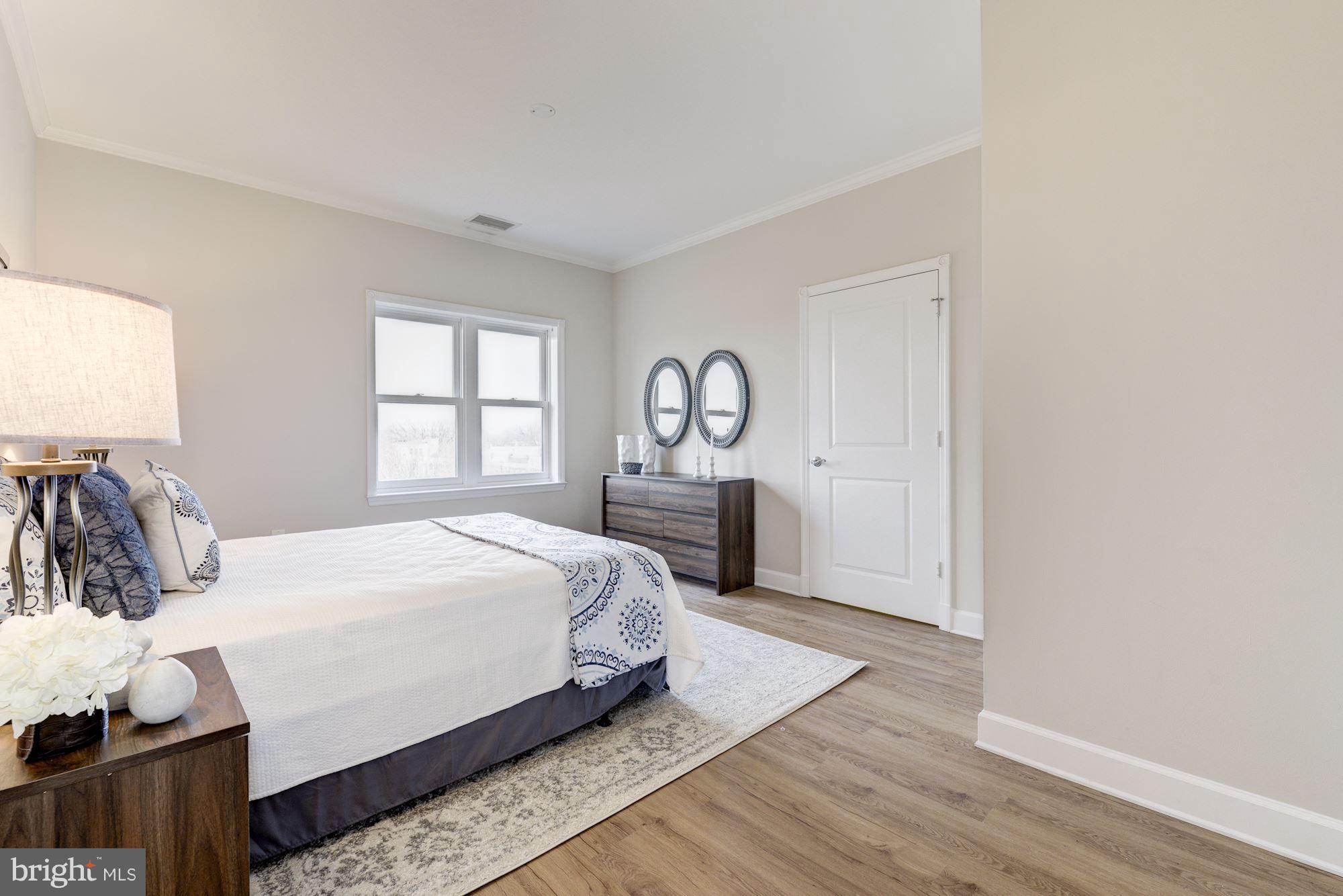 401 13th Street Northeast, Unit PH8 Washington, DC 20002 - Photo 16 of 27 a bedroom with a bed and wooden floor
