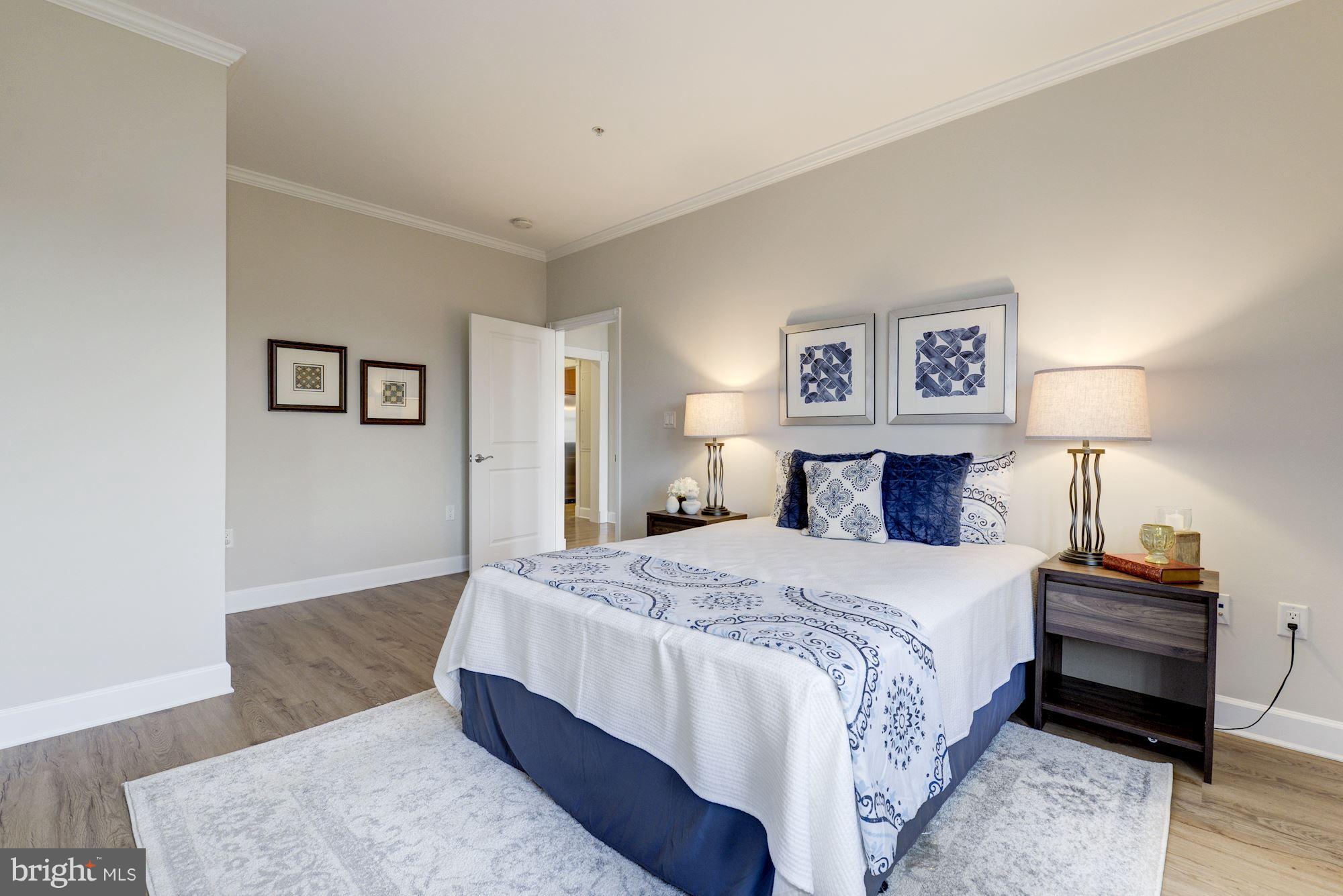 401 13th Street Northeast, Unit PH8 Washington, DC 20002 - Photo 18 of 27 a spacious bedroom with a bed and a lamp
