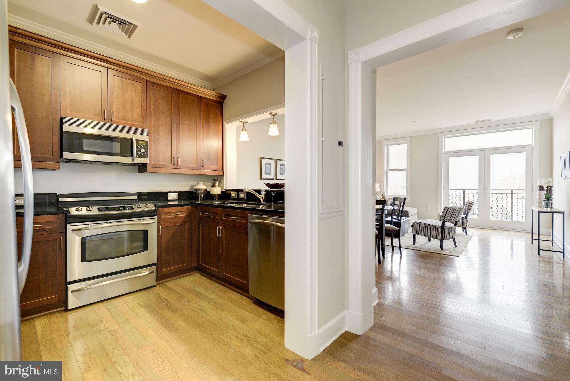 401 13th Street Northeast, Unit PH8 Washington, DC 20002 - Photo 4 of 27 a kitchen with granite countertop a stove a sink and a refrigerator