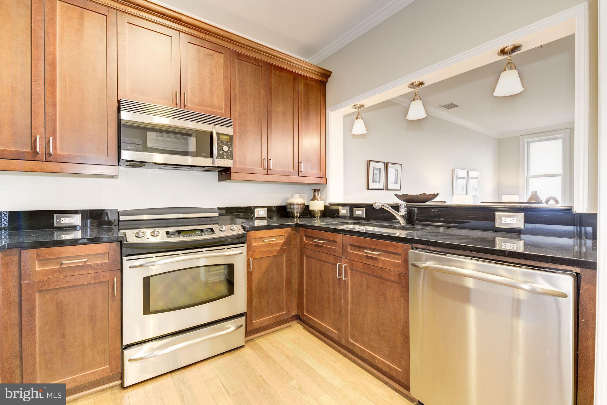 401 13th Street Northeast, Unit PH8 Washington, DC 20002 - Photo 7 of 27 a kitchen with stainless steel appliances granite countertop a stove and a microwave