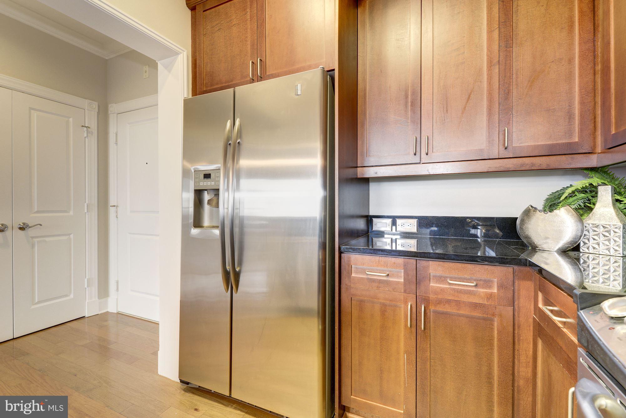 401 13th Street Northeast, Unit PH8 Washington, DC 20002 - Photo 9 of 27 a kitchen with granite countertop a refrigerator and cabinets