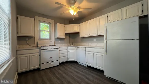 a kitchen with granite countertop white cabinets and white appliances