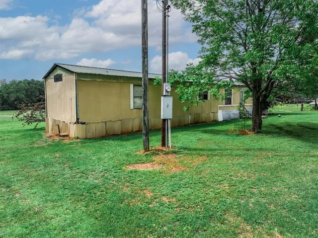 a view of a house with backyard and sitting area