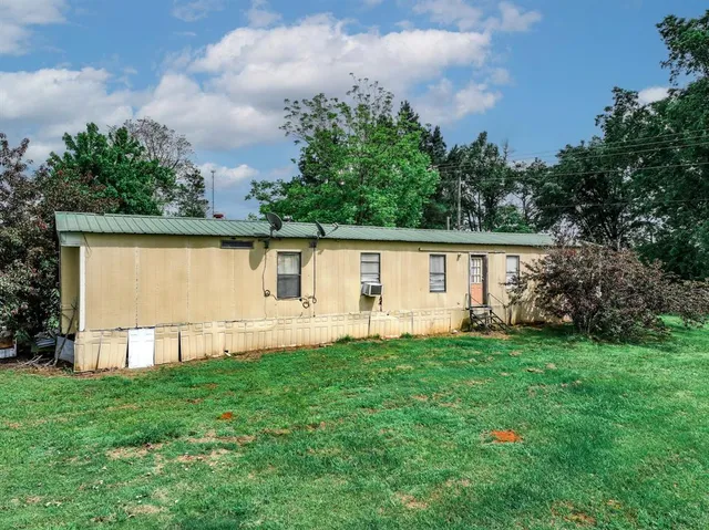 a front view of a house with a yard and trees