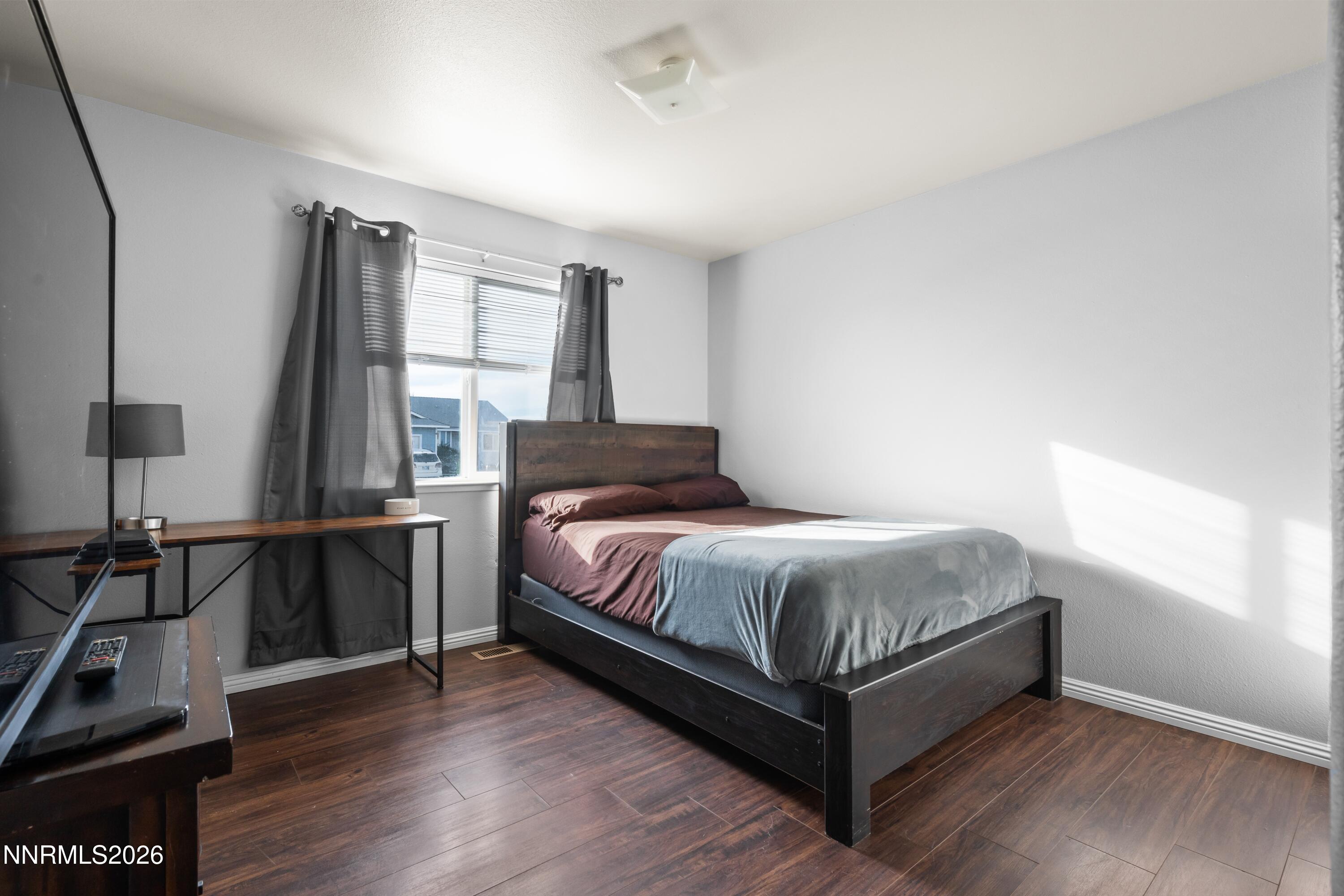 712 Hastings Way Fernley, NV 89408 - Photo 13 of 36 a bedroom with a bed and wooden floor
