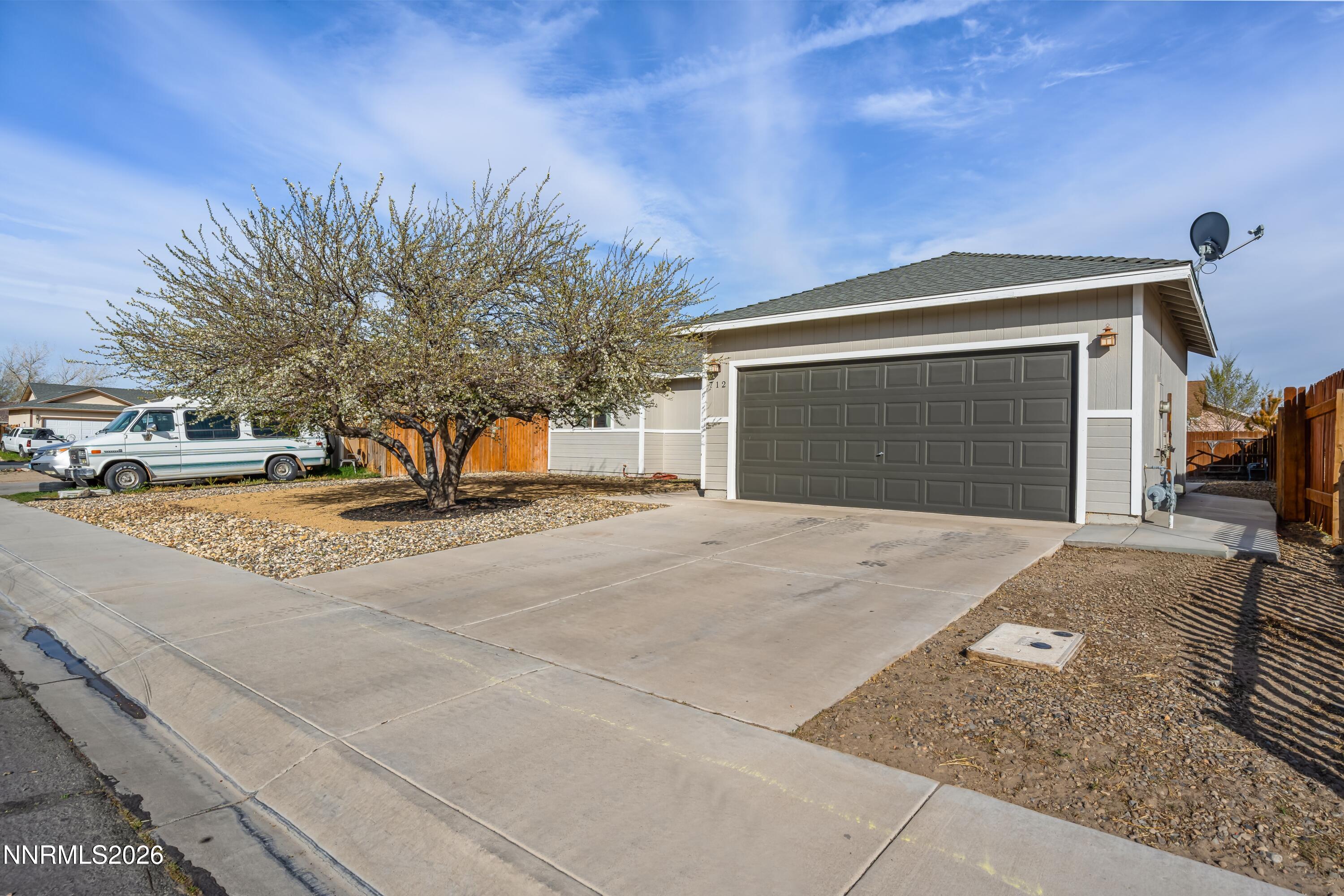 712 Hastings Way Fernley, NV 89408 - Photo 2 of 36 a front view of a house with a yard and garage