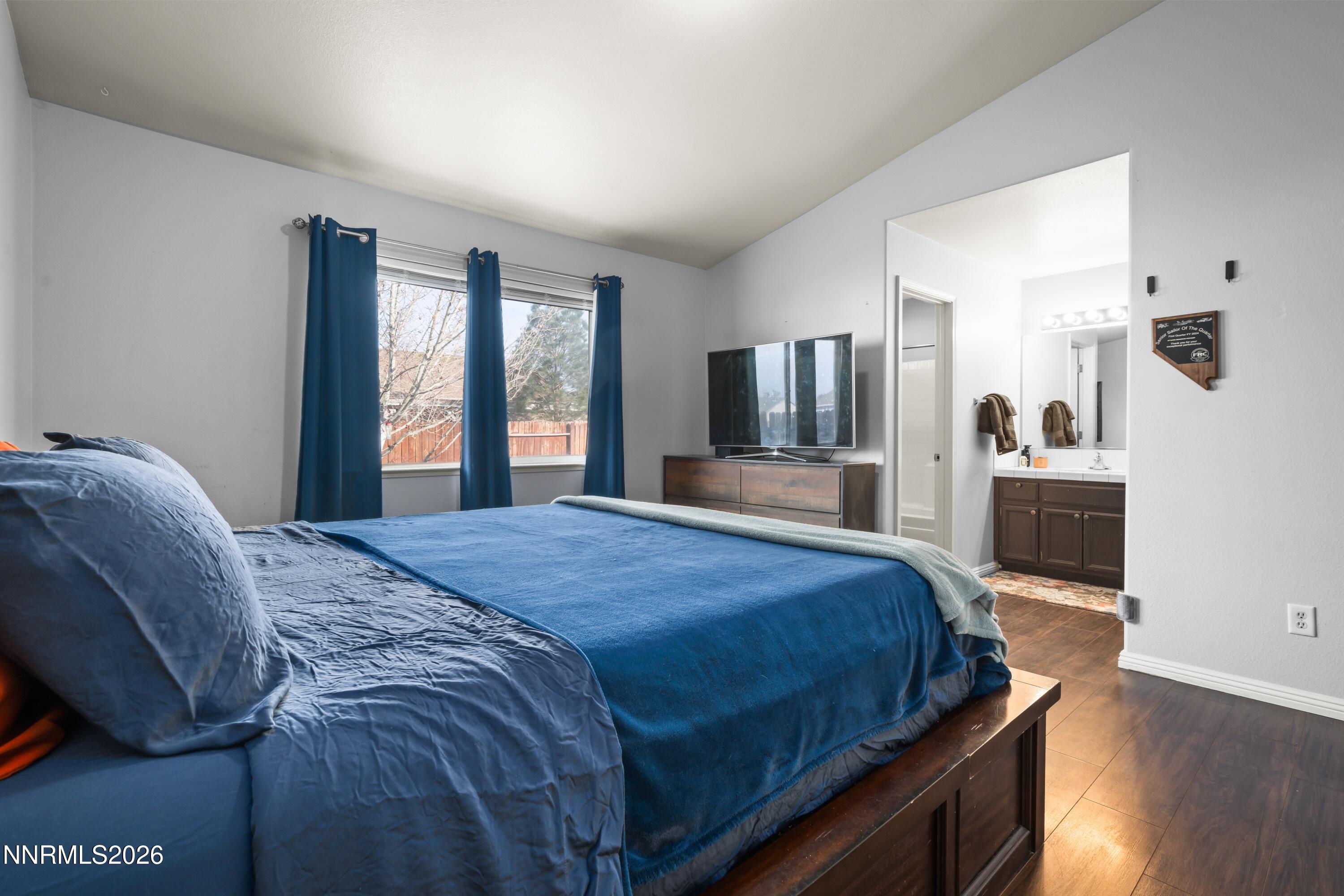 712 Hastings Way Fernley, NV 89408 - Photo 10 of 36 a bedroom with a large bed and a flat tv screen on dresser