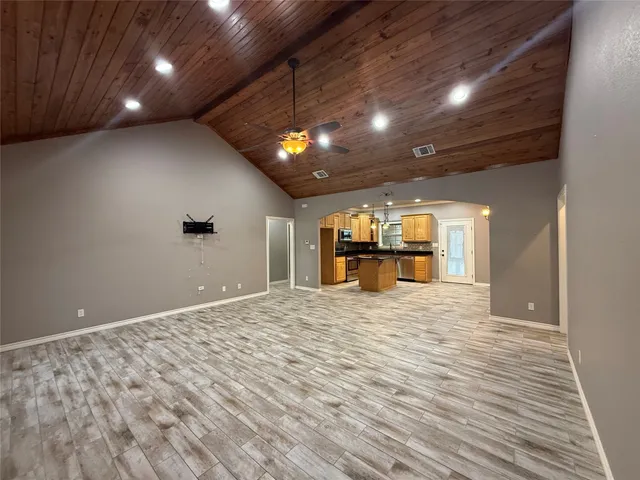 a kitchen with stainless steel appliances kitchen island granite countertop a refrigerator and a stove top oven