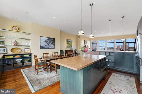 a kitchen with stainless steel appliances granite countertop a sink a stove and a wooden floors