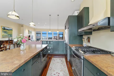 a kitchen with stainless steel appliances granite countertop a sink a stove and refrigerator