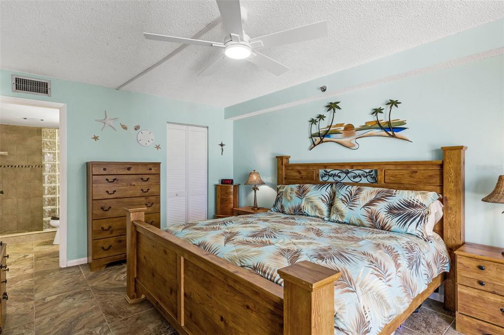 14900 Gulf Boulevard, Unit 410 Madeira Beach, FL 33708 - Photo 16 of 76 a bedroom with a bed and a tv on the dresser