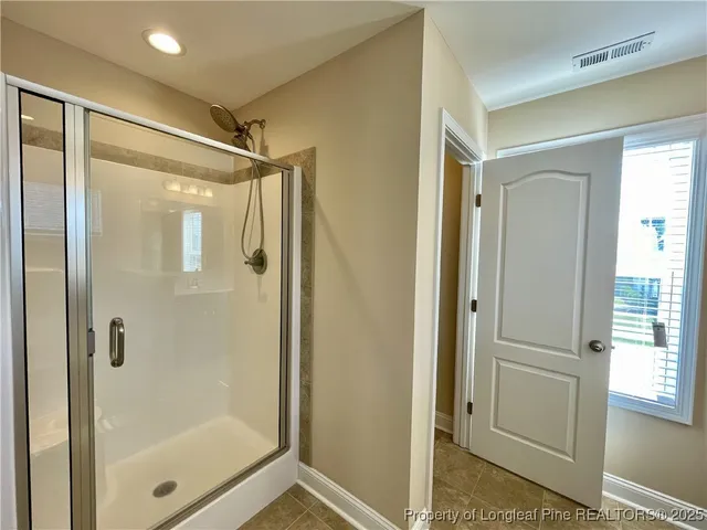 a bathroom with a glass shower door and a glass door