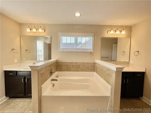 a spacious bathroom with a tub sink shower and mirror