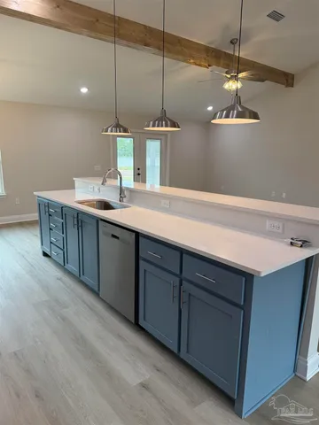an empty room with wooden floor cabinet and windows