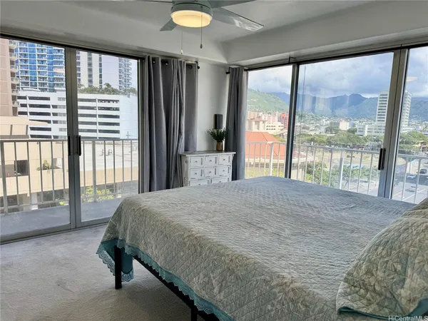 a bedroom with a bed and a large window with outer view