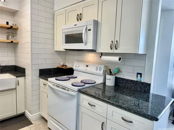 a kitchen with stainless steel appliances granite countertop a sink stove and cabinets
