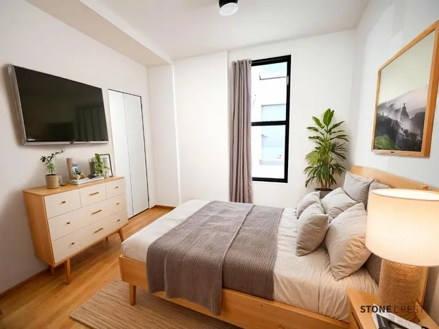a bedroom with a bed and a flat screen tv