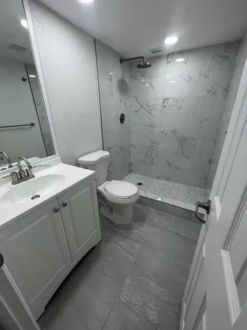 a bathroom with a double vanity sink toilet and shower