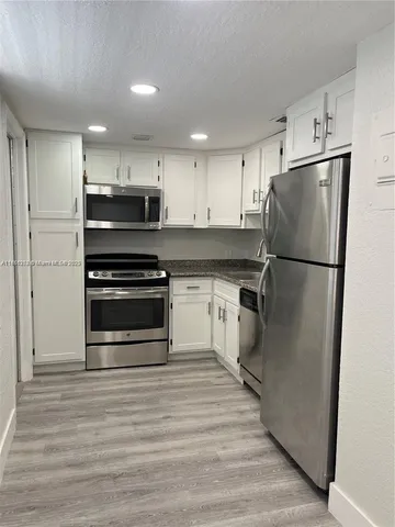 a kitchen with a refrigerator and a stove top oven