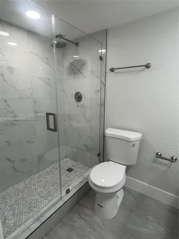 a white toilet sitting next to a bath tub and shower