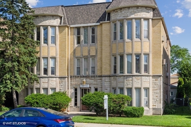 a front view of a residential apartment building with a yard