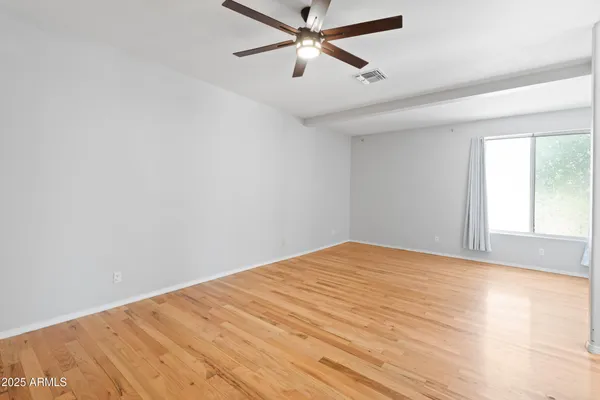 a view of a big room with wooden floor and windows in a room