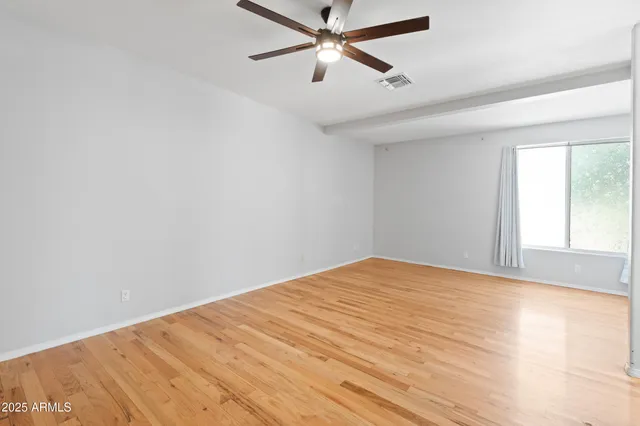 a view of a big room with wooden floor and windows in a room