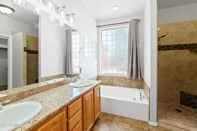 a bathroom with a granite countertop tub sink and a shower