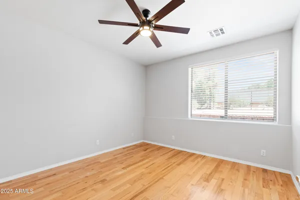 a view of a big room with wooden floor and a ceiling fan