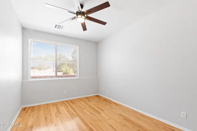 an empty room with a window and a fan