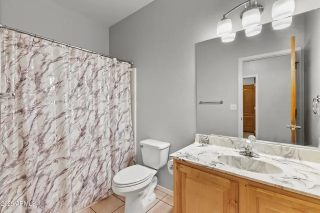 a bathroom with a granite countertop sink toilet and a mirror