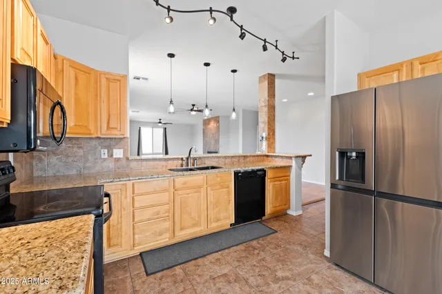 a kitchen with stainless steel appliances granite countertop a refrigerator and a sink